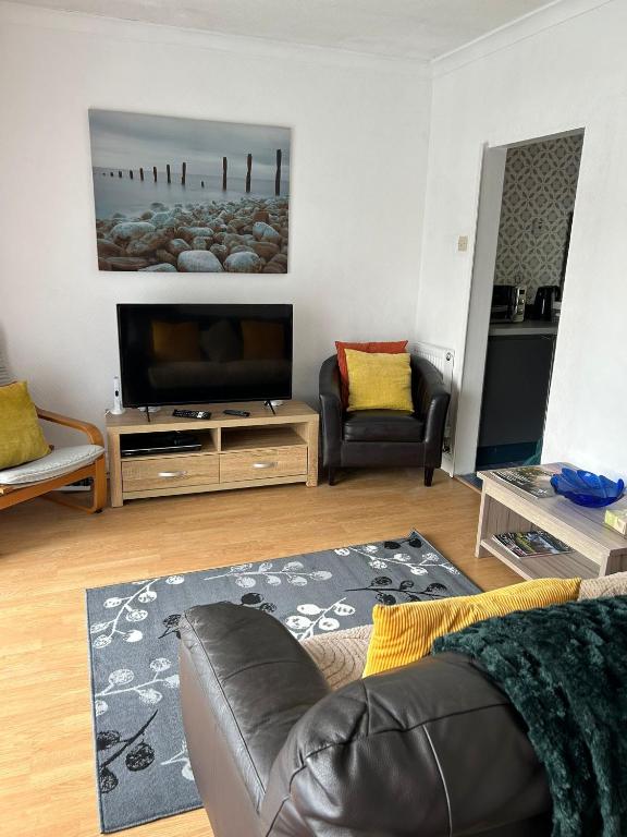 a living room with a couch and a flat screen tv at Affordable Saundersfoot Holidays in Pembrokeshire