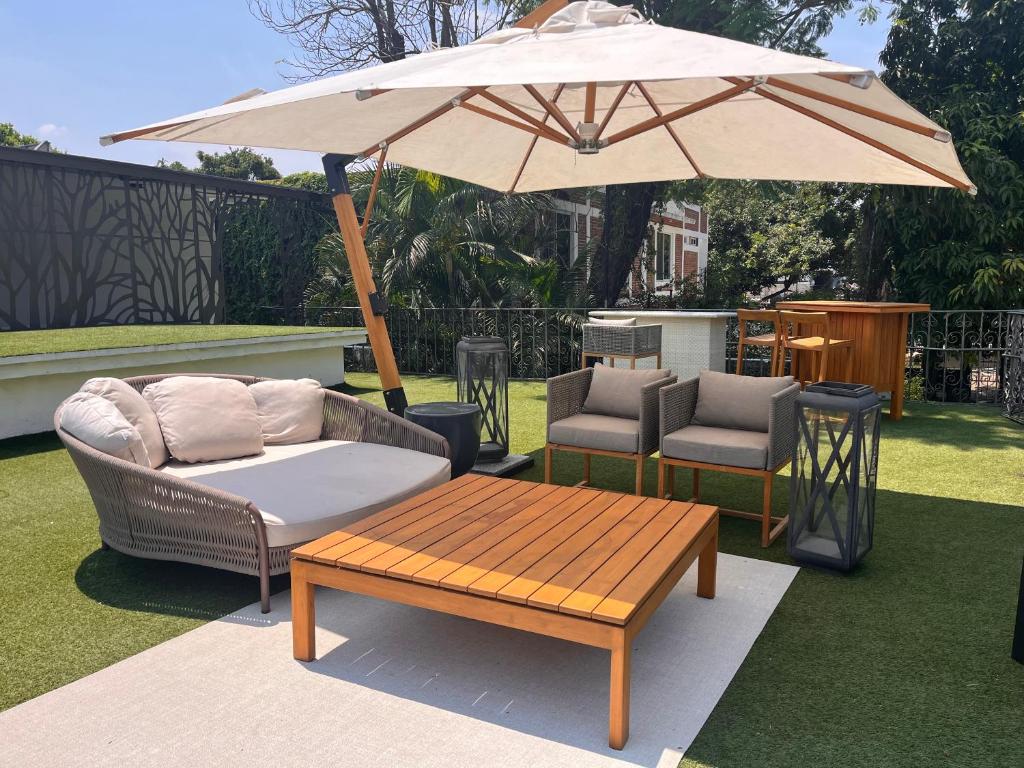 a patio with a table and an umbrella and chairs at Hotel Boutique Casa Ceibas in Cuautla Morelos