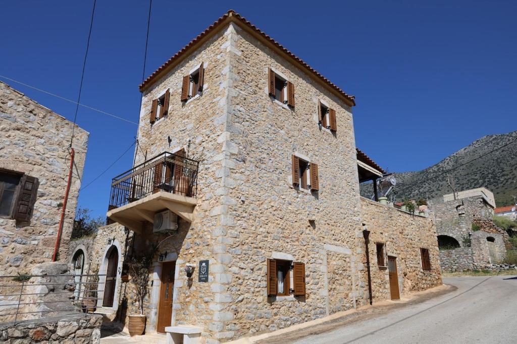 a stone building with a balcony on the side of it at Stratis Tower Since 1892 in Oitylo