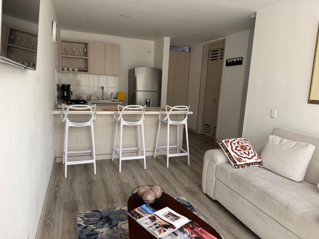 a living room with a couch and a kitchen at Apartamento frente a Mallplaza in Manizales