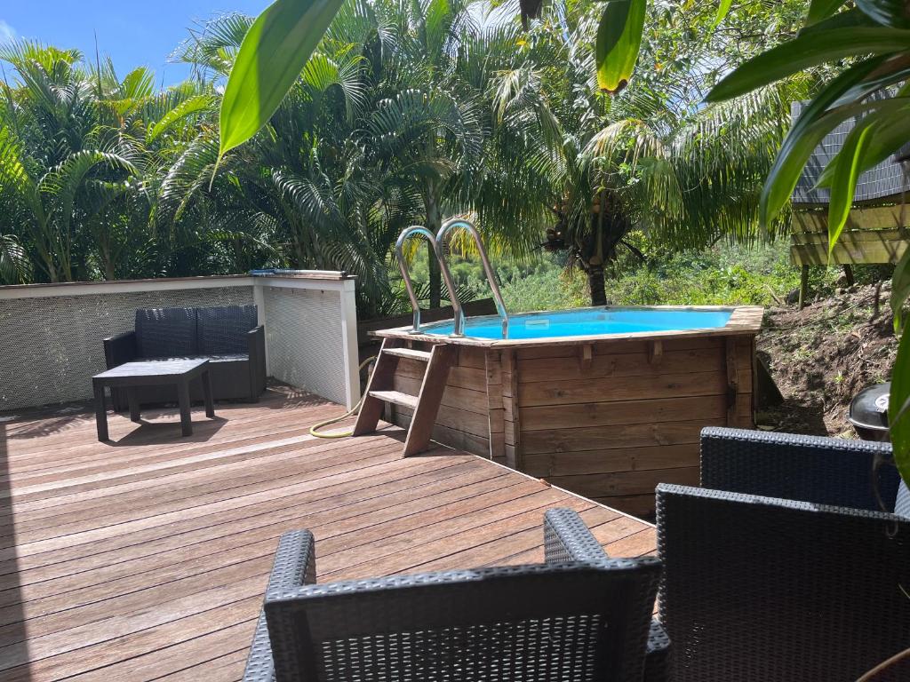 a wooden deck with a hot tub and chairs at Villas smoothie SYCARO in Le François