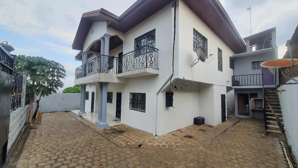 a white house with balconies and a courtyard at Manoir des Princesses in Yaoundé