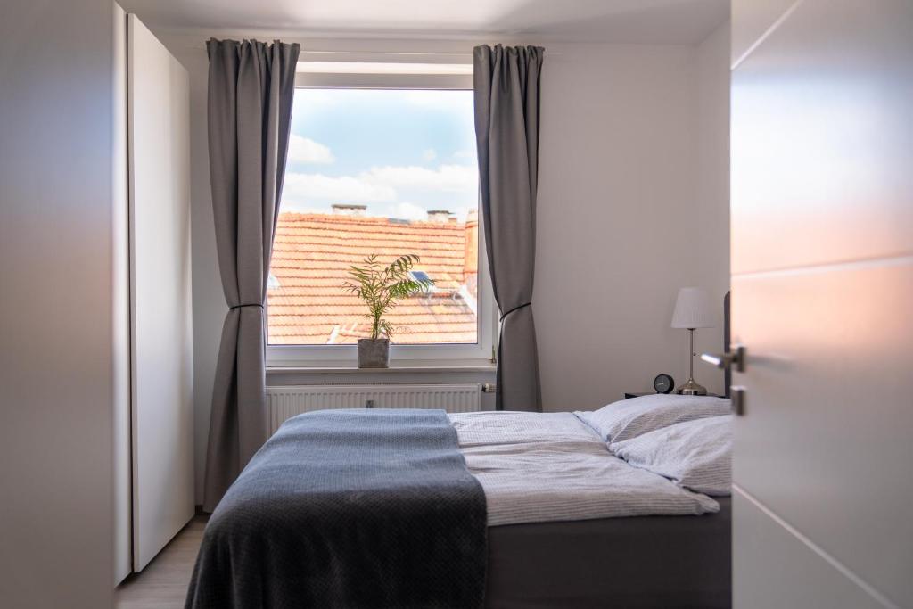a bedroom with a bed and a window at Interior Apartments - Service Apartments in Bahnhofsnähe und UNESCO-Bergpark mit Parkplatzmöglichkeit, EBK, kinderfreundlich, Familienzimmer in Kassel