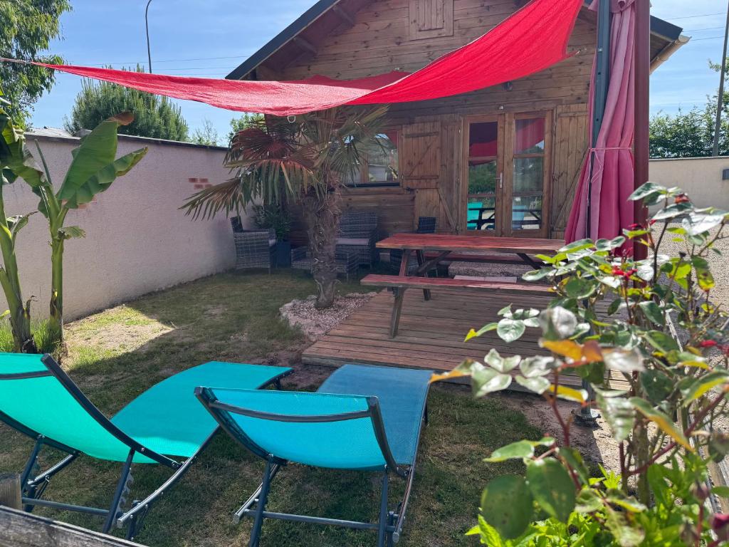 two chairs and a picnic table in front of a cabin at " domaine des chevrettes chalet cosy au cœur des châteaux " in Cour-Cheverny