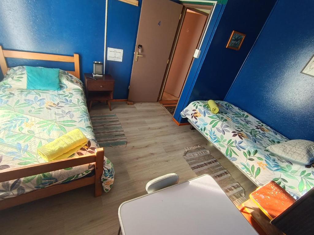 a small room with two beds and a table at Kramm House Aldea 47 in Coihaique
