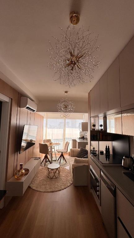 a kitchen and living room with a chandelier at Premium Suite - Perdizes - Luxury & Panoramic View in São Paulo