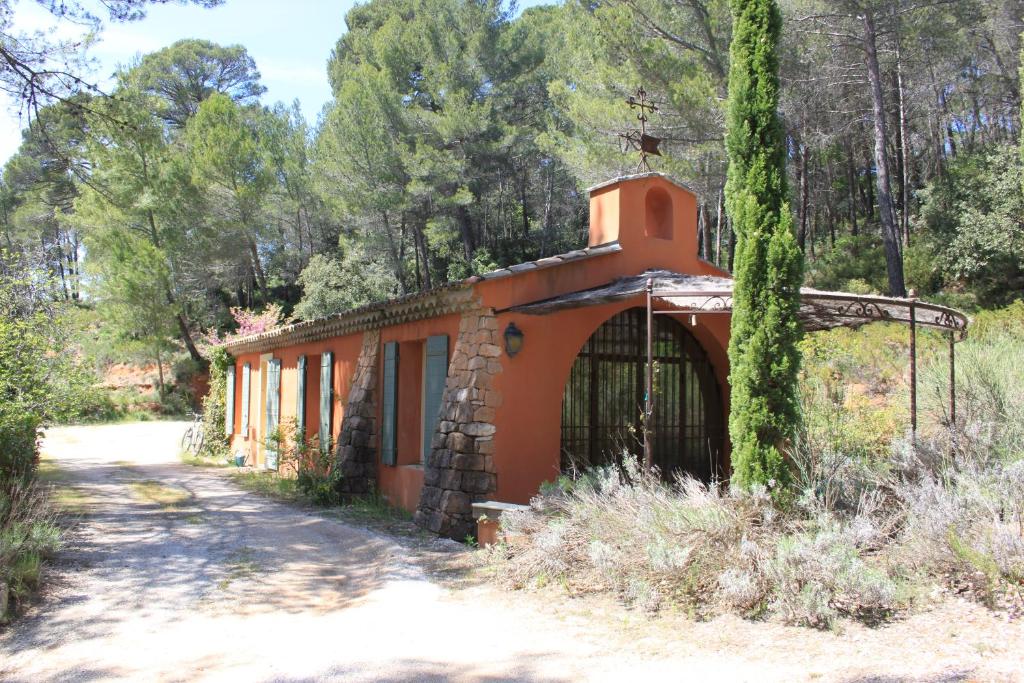 un bâtiment orange avec un arbre à côté d'un chemin de terre dans l'établissement La Petite Yolande, à Aix-en-Provence