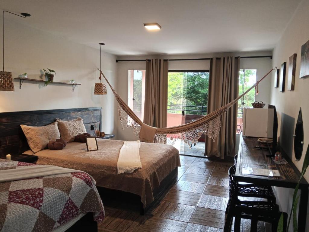 a bedroom with two beds and a hammock in it at Hotel Sinhá in Tianguá
