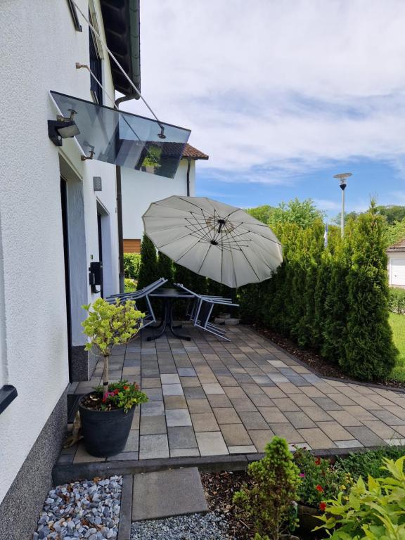 a patio with a table and an umbrella at Ferienwohnung in Olpe-Rhode am Biggesee in Olpe