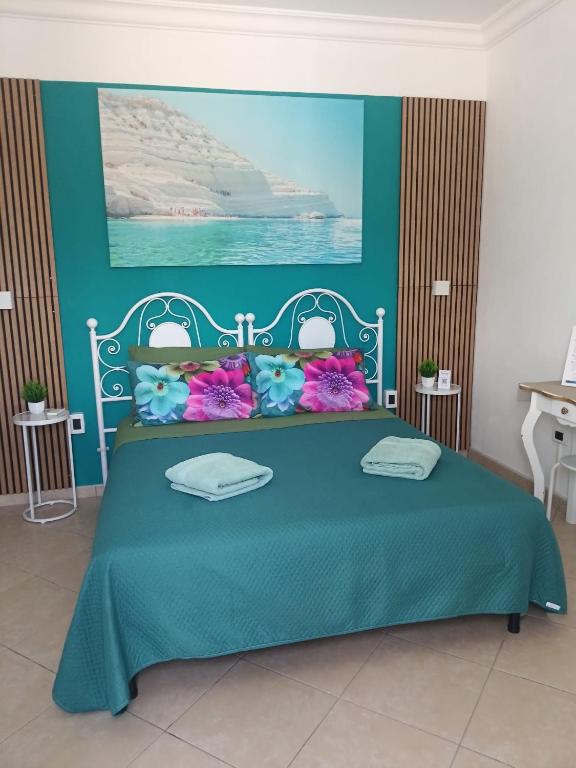 a bedroom with a blue bed with flowers on it at M'arriposu in Realmonte