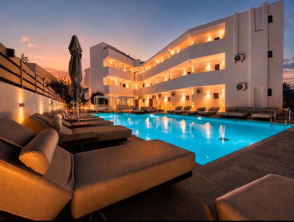 a large building with a swimming pool at night at Penélope Hotel in Ialysos