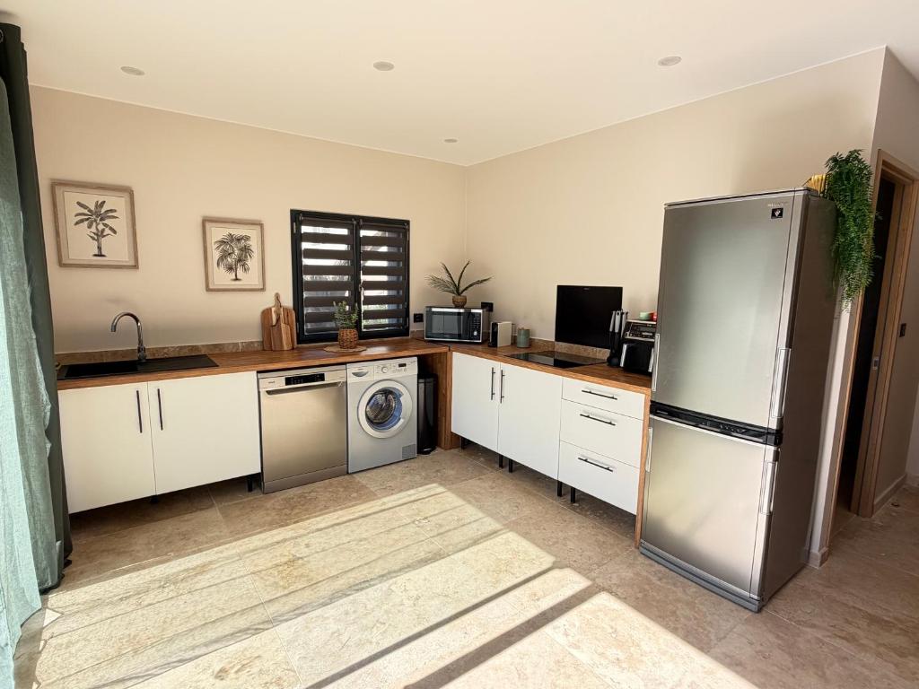 a kitchen with a refrigerator and a washer and dryer at Douce Évasion in Beauvoisin