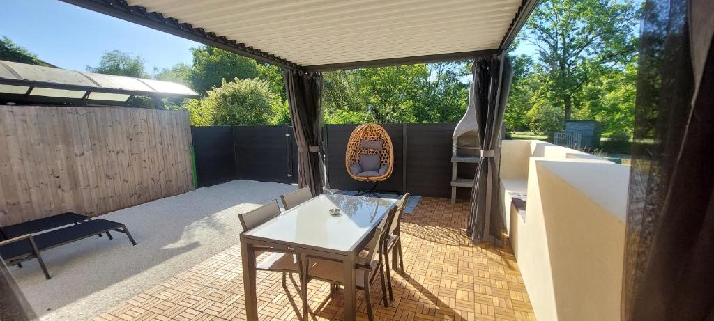 a patio with a table and a mirror on it at Gite Rive Charente La Cabane in Bords