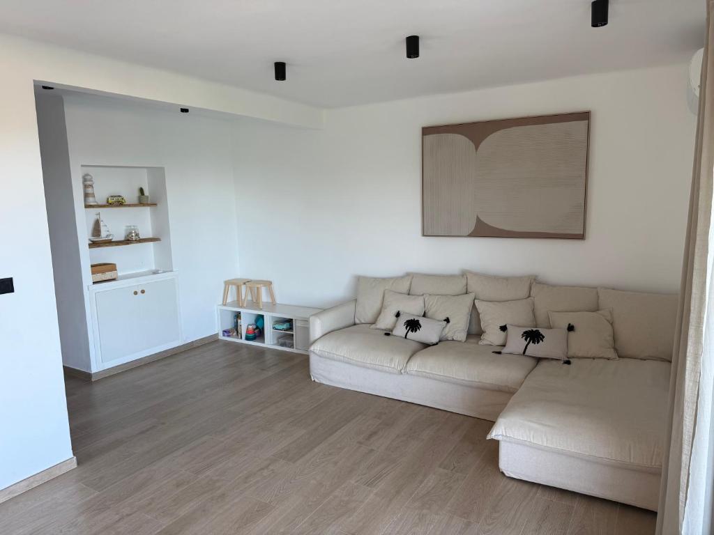 Ein weißes Wohnzimmer mit weißem Sofa und Holzboden in der Unterkunft Farelleta in Llança