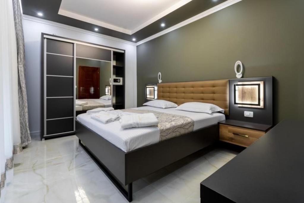 a bedroom with a large bed and a mirror at APART-HOTEL PRESiDENT 2 in Ulcinj