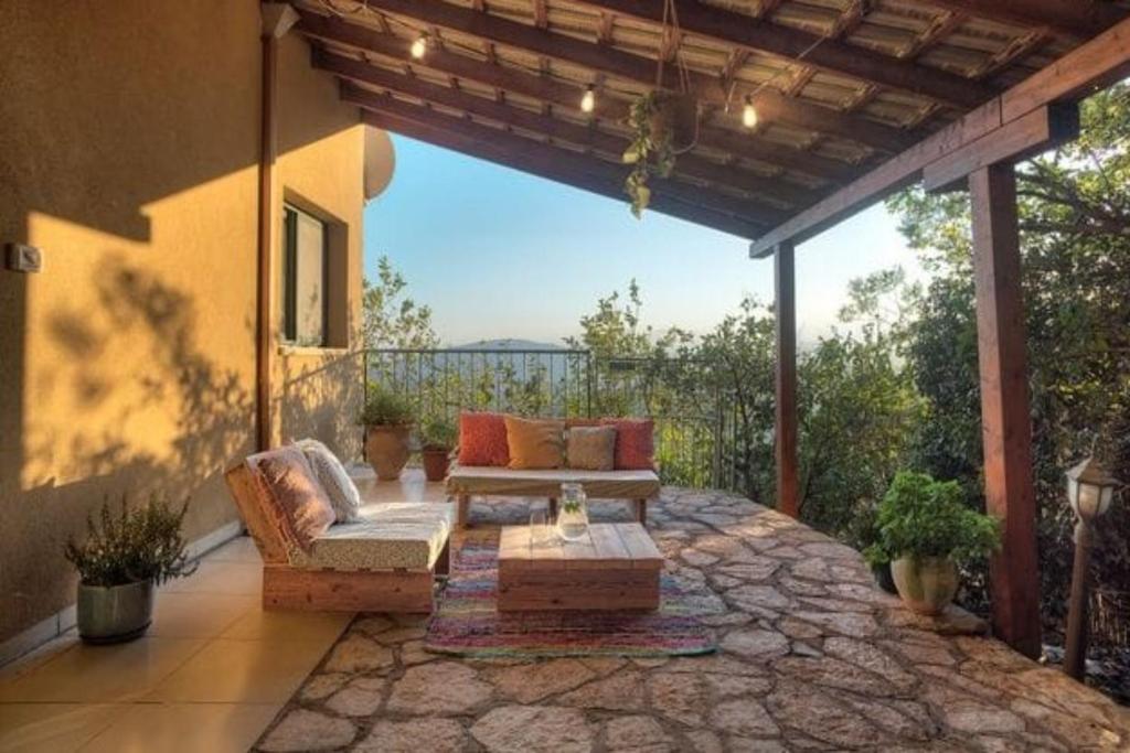 an outdoor patio with a couch and a table at קצה ההר in Amirim