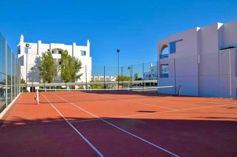 a tennis court in front of a building at Elegant Beach View Apartment in Kabila Vista in Marina Smir