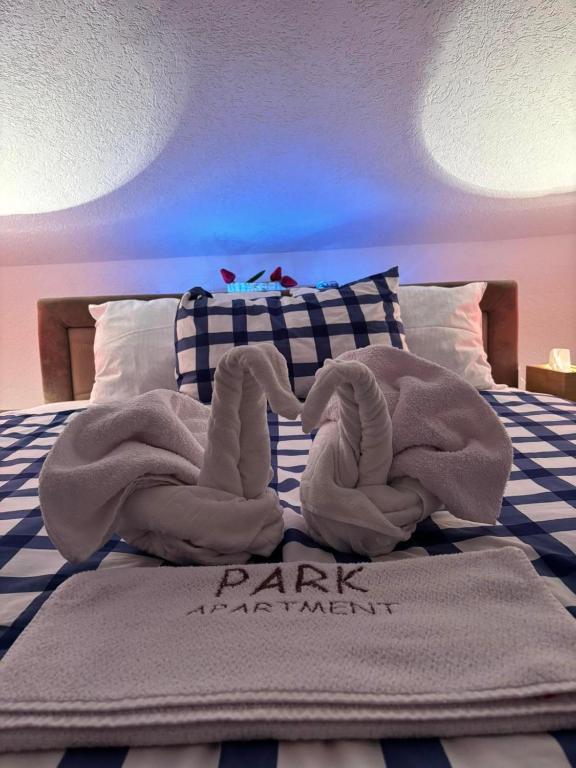 a bed with two towels on top of it at Park Apartment in Kočani