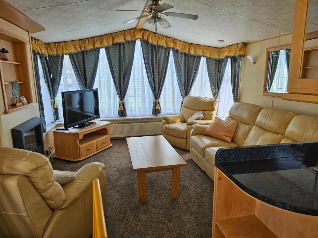 a living room with couches and a flat screen tv at Bella in Skegness