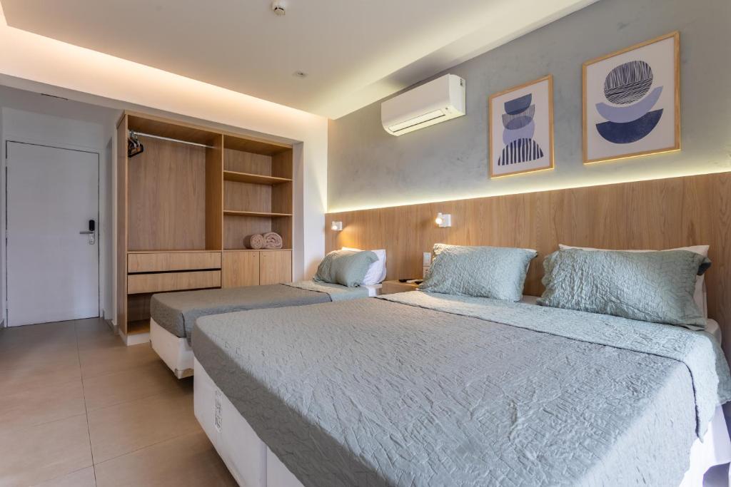 a hotel room with two beds and a closet at Flat Central Arena Policia Federal in Brasília