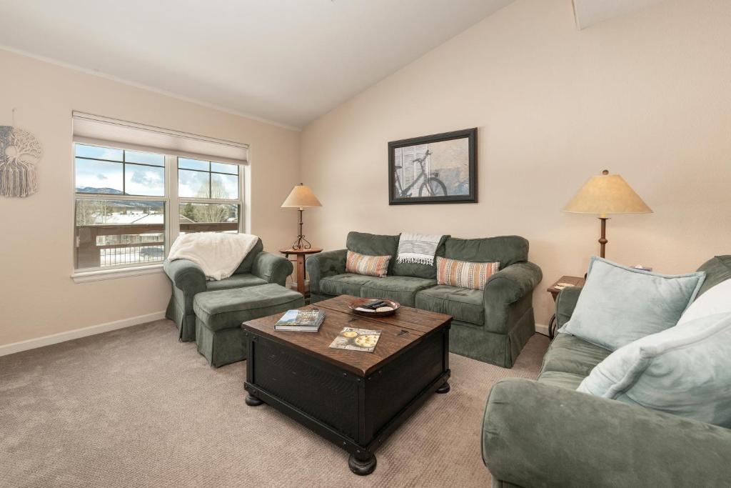 a living room with two couches and a table at Waterside West A206 in Fraser