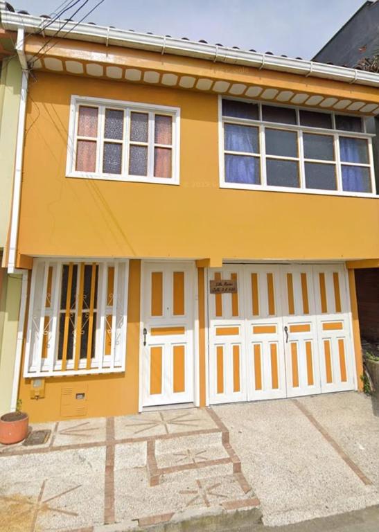 a yellow house with white doors at Alojamiento donde Nur in Filandia
