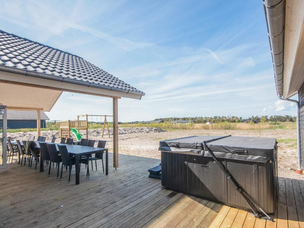 a deck with a table and chairs and a grill at 5 star holiday home in Jerup in Jerup