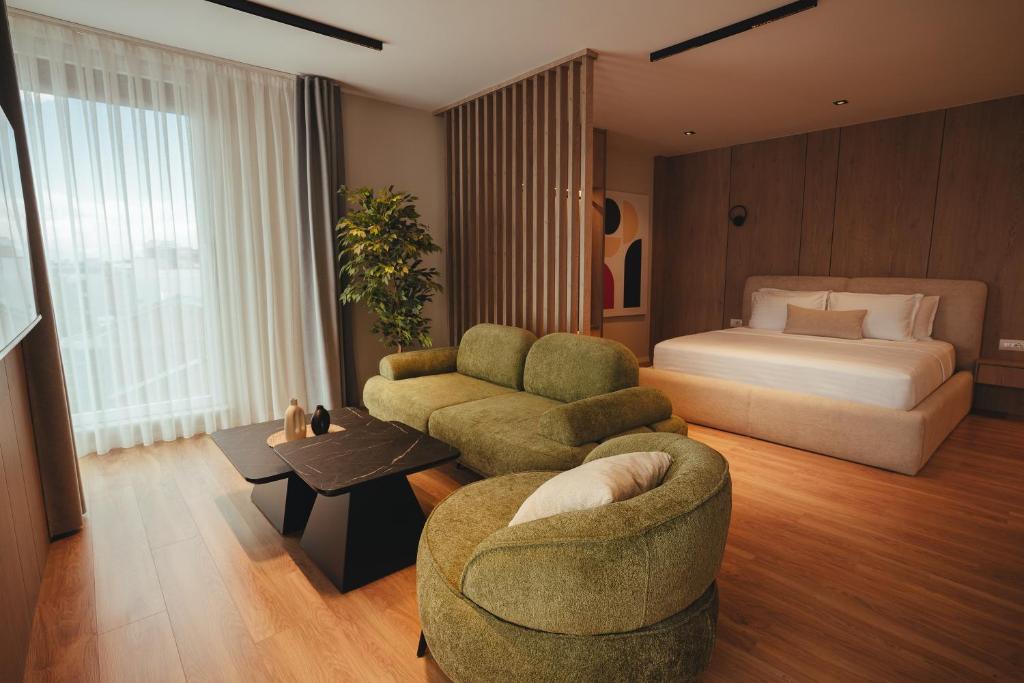 ein Hotelzimmer mit Bett, Sofa und Stühlen in der Unterkunft Noir Hotel in Gjakove