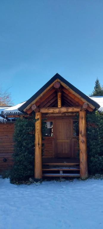 a log cabin with snow on the ground in front of it at Las Carpitas in Villa Mascardi