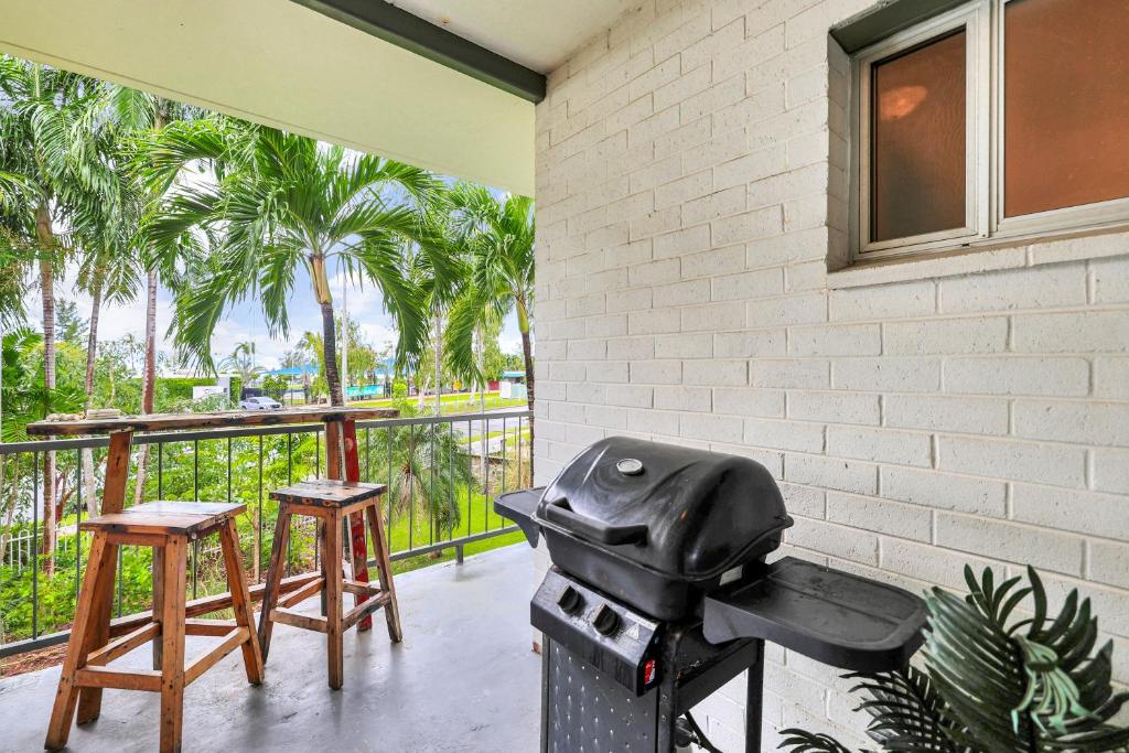 a grill sitting on a porch with two stools at Beachfront Bliss Studio Apt on the Foreshore in Nightcliff