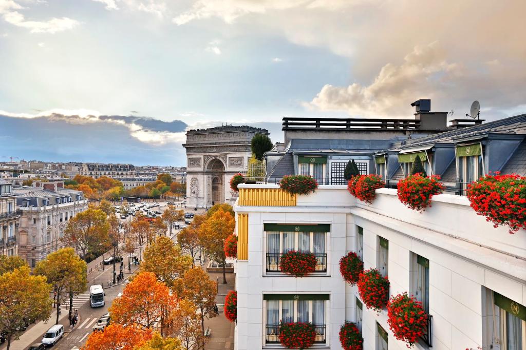 uma vista para uma cidade com flores sobre um edifício em Hôtel Napoleon Paris em Paris