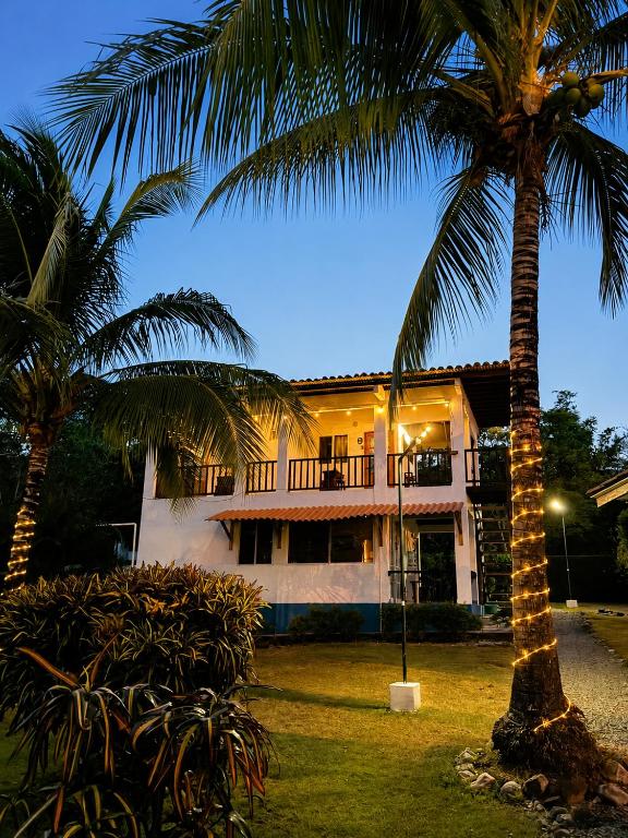 a house with two palm trees in front of it at Entre Palmas Venao in Playa Venao