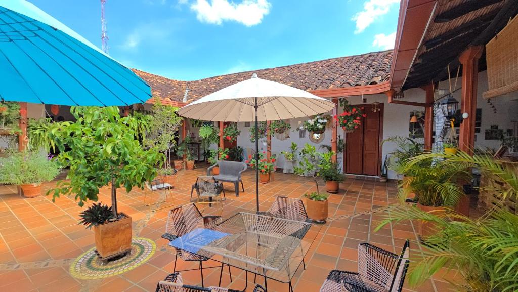 a patio with a table and chairs and an umbrella at La Casona Espacio Bonito in Zapatoca