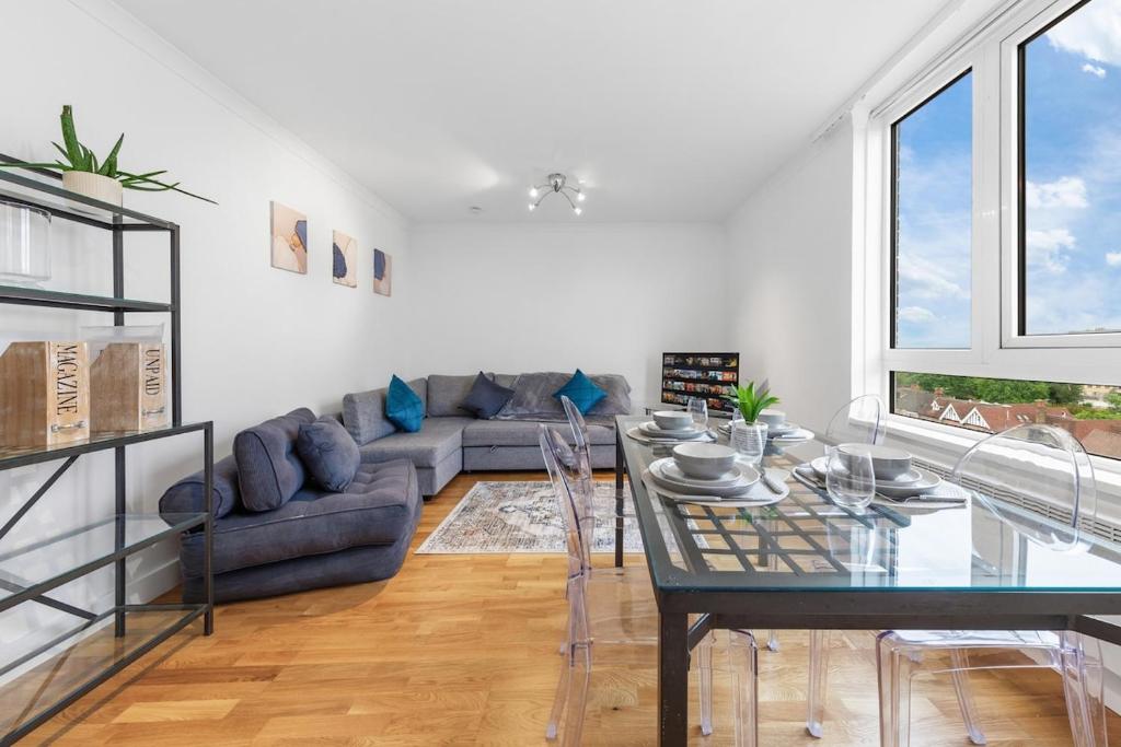 a living room with a couch and a glass table at Modern 2 Bed Flat 5 mins Ealing Broadway Station in Ealing