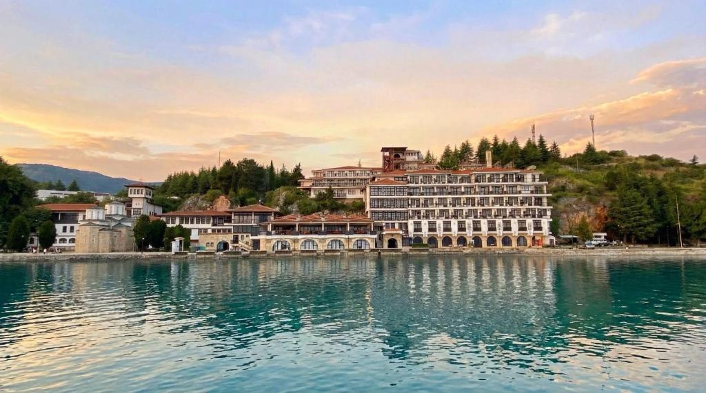 a large building on the shore of a body of water at Hotel Biser in Kališta