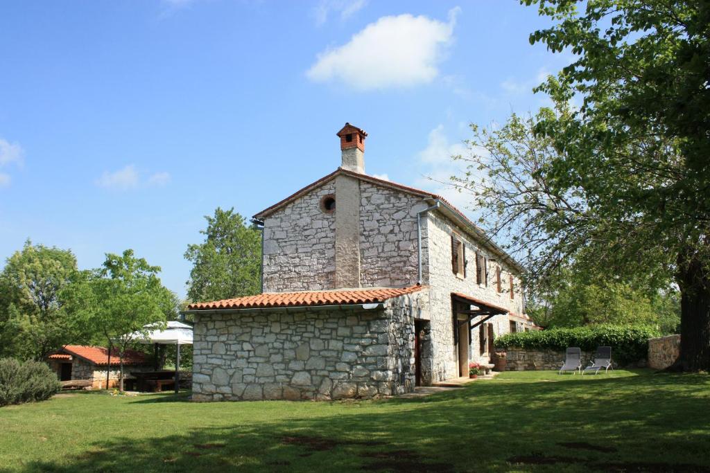 an old stone building with a chimney on top of it at House Kisic in Višnjan