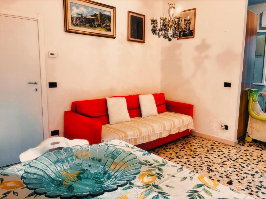 a living room with a red couch and a chair at Bed and Break fast JIREH in Casalecchio di Reno