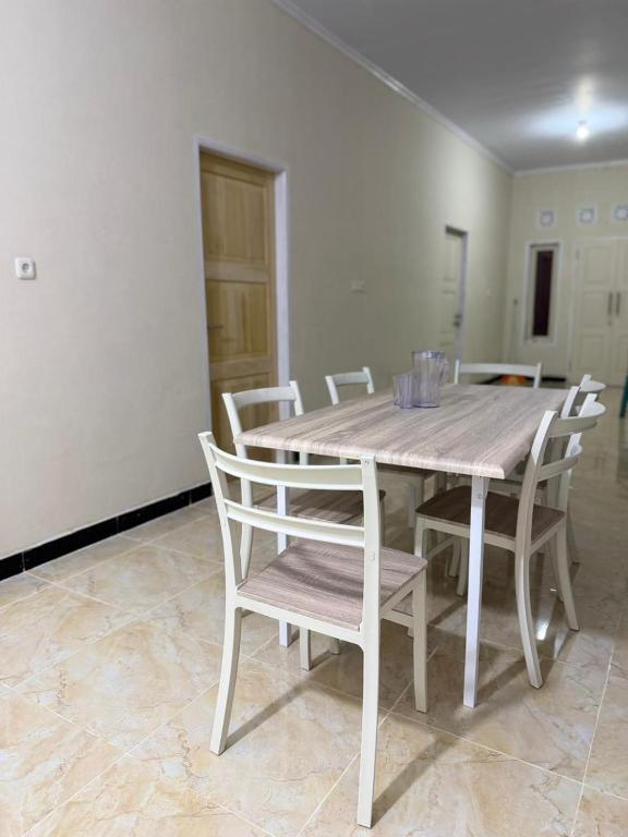 a wooden table and chairs in a room at Homestay Whale Shark in Pohe