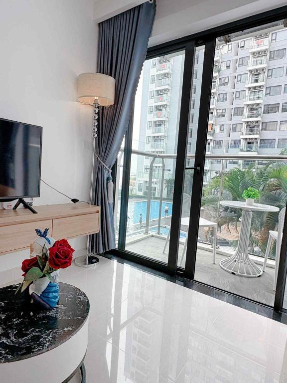 a living room with a television and a large window at Hiền Apartment in Thôn Văn Dương