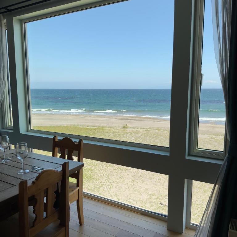 a dining room with a view of the beach at Seaside Inn KOKOMO in Hakodate