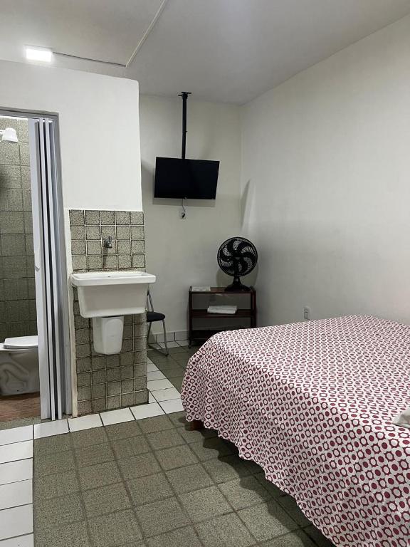 a bathroom with a bed and a sink at Pousada São Paulo - Quartos com WC Exclusivo in Recife
