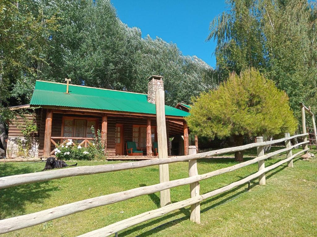 a wooden fence in front of a house at Cabañas La Brama in Aluminé
