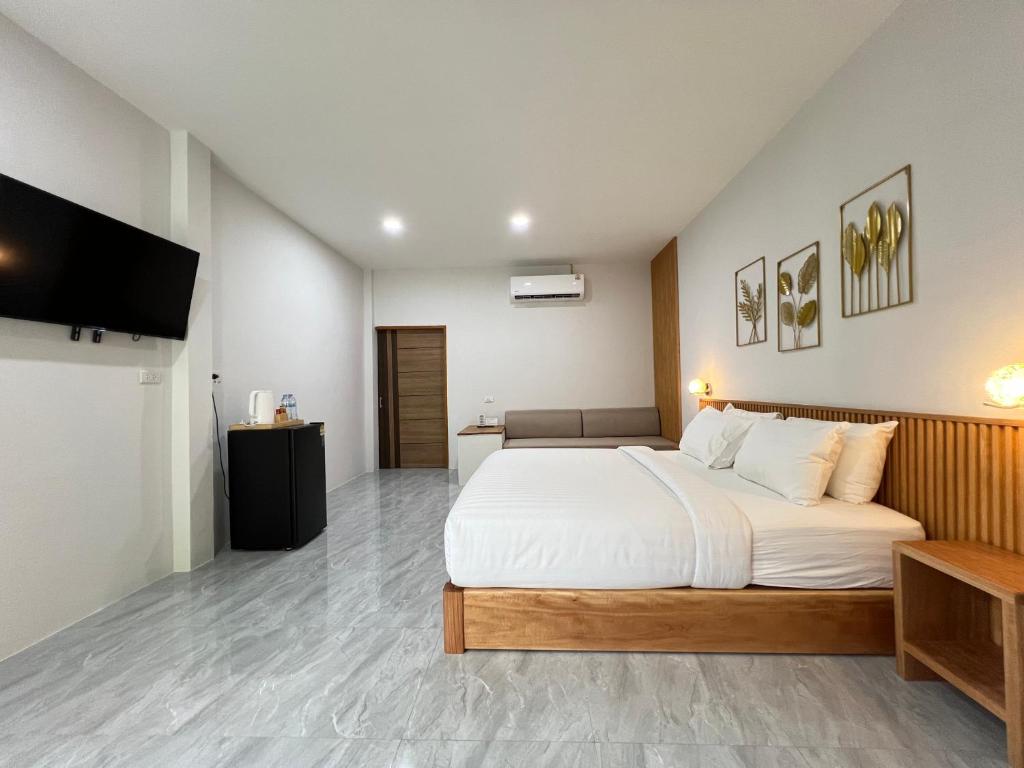 a bedroom with a large bed and a flat screen tv at Wilawan home in Ko Samui