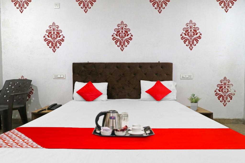 a hotel room with a bed with a red blanket at Hotel O Fox Guest House in Greater Noida