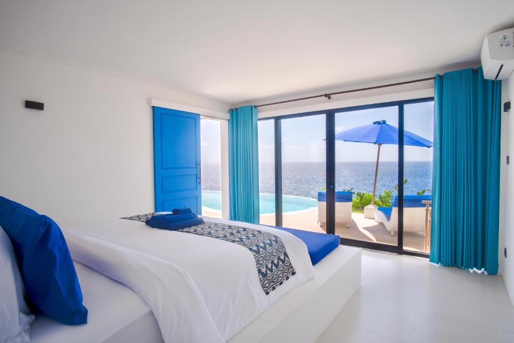 a bedroom with a bed and a view of the ocean at NEW! 2BR Ocean View, Infinity Pool, Villa Kerylos in Sampalan