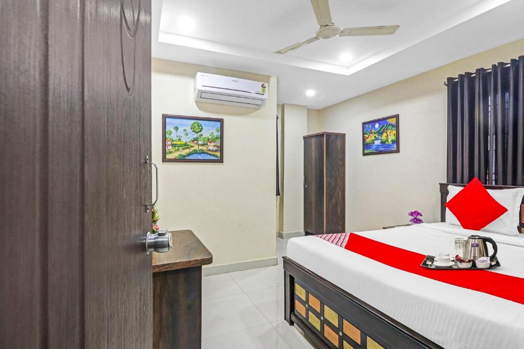 a bedroom with a bed with a red blanket at Super Hotel O Honey Heights Near Botanical Garden in Kondapur