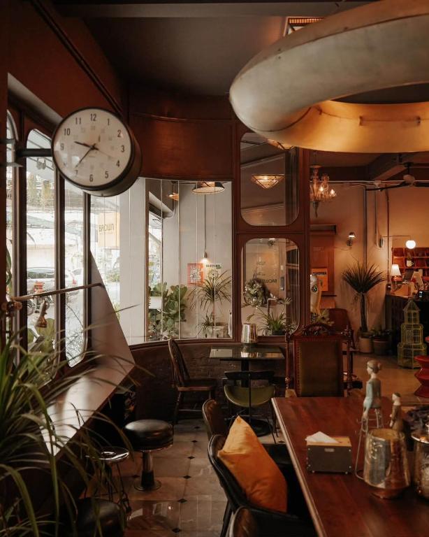 eine Uhr, die an der Wand eines Restaurants hängt in der Unterkunft Brown H in Pom Prap