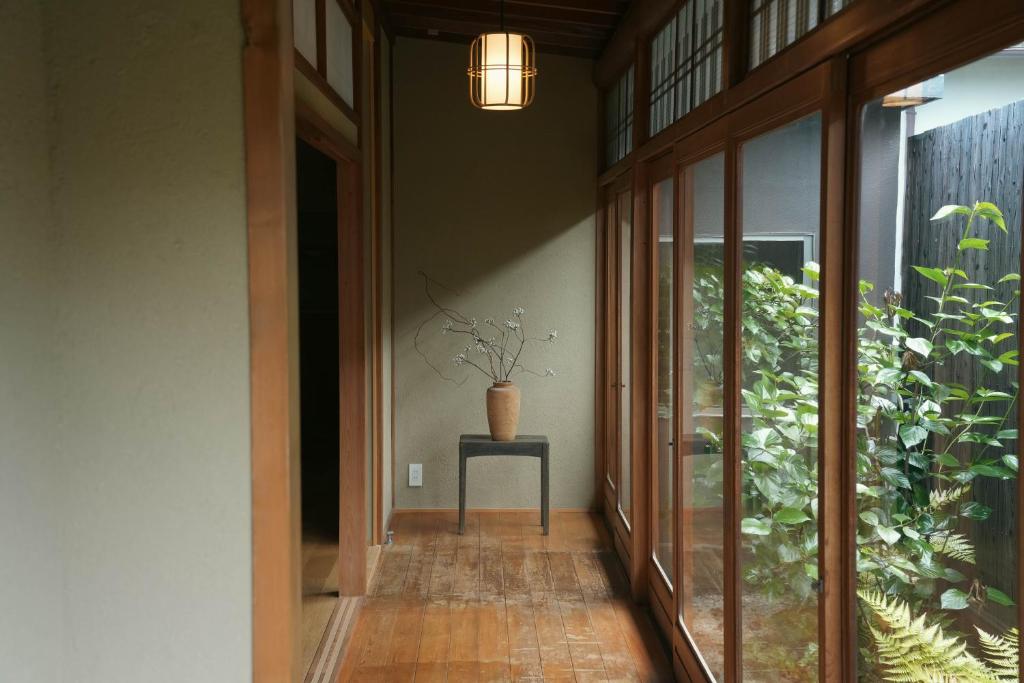 a hallway with a potted plant on a table at 宿屋 余白丨yadoya yohaku in Wakayama