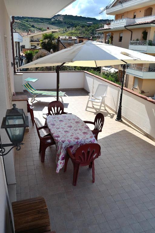 a table and chairs on a balcony with an umbrella at Appartamenti In Residence Zoe in Roseto degli Abruzzi