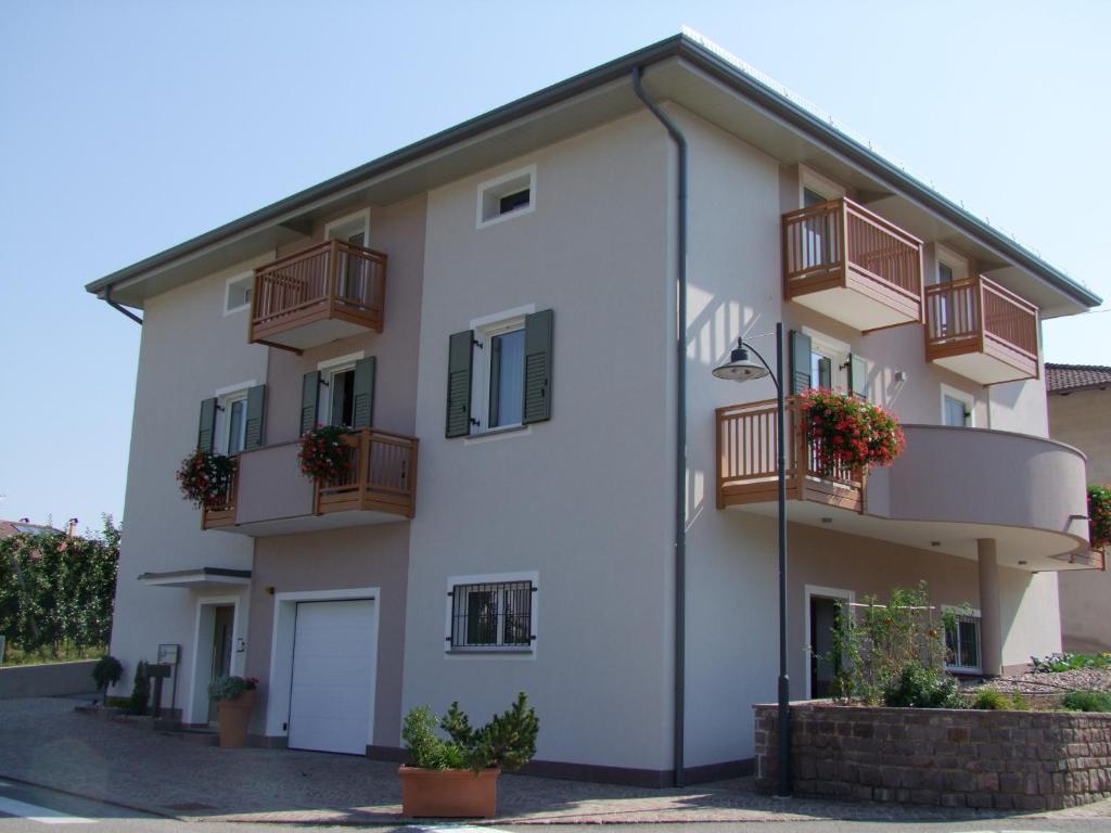 um edifício de apartamentos branco com varandas em Agritur Fior di Melo em Nanno